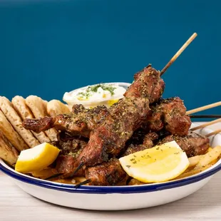 skewered meat with lemon wedges