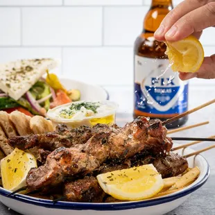 a person putting lemon wedges on a skewer