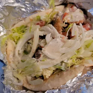 Gyro in pita with lettuce, tomato, onion, and tzatziki sauce