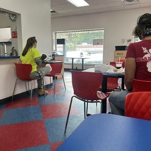 a woman sitting at a table in a fast food restaurant