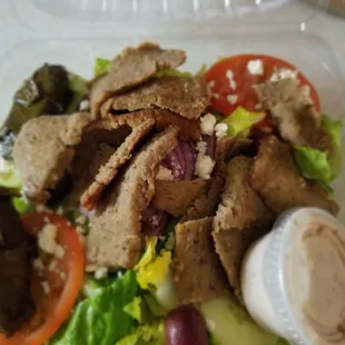 Mediterranean salad with beef. Dressing on the side. This is a big salad. Fresh veg.
