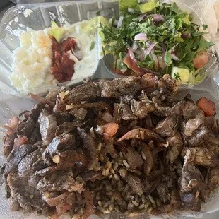 Lamb and beef platter with salad and garlic, fire, and tzaziki spreads