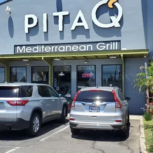 two cars parked in front of a restaurant