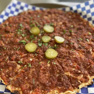 a pizza with pickles on it