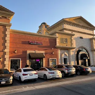 a row of cars parked in front of a restaurant