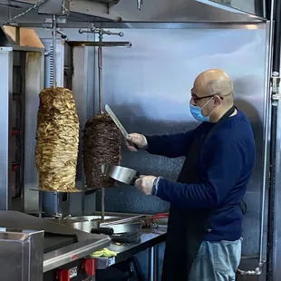 a man wearing a face mask preparing food