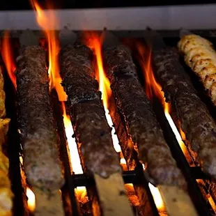 a variety of meats being cooked on a grill