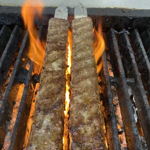 two pieces of meat being cooked on a grill