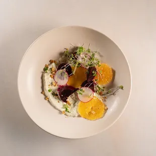 a plate of food with oranges and radishes