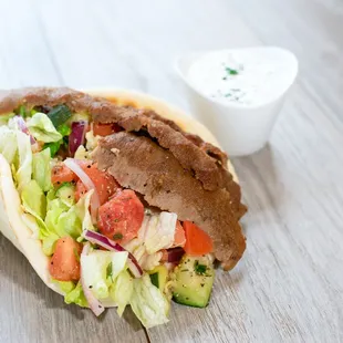 a pita sandwich on a wooden table