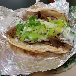 Unwrapped Gyro with lots of lamb &amp; beef Gyro meat, shredded lettuce, onions, tomatoes and tzatziki sauce on a warm pita.