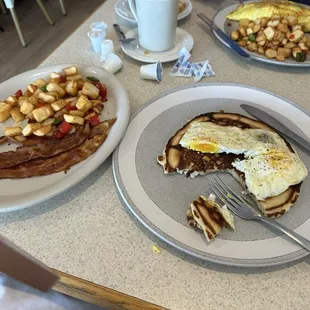 Two eggs over pancake, and home fries with bacon.