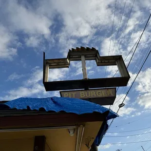 a sign for a restaurant with a blue tarp covering it