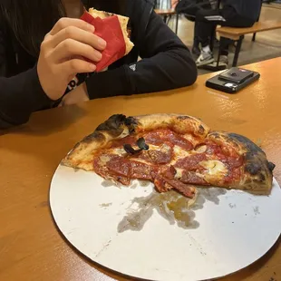 a girl eating a slice of pizza