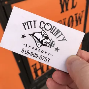 a hand holding a business card