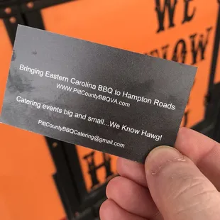 a hand holding a business card