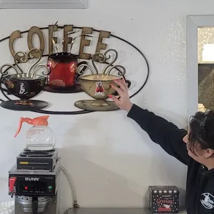Keisha showing the Scout and Buddy magnets on the coffee cups