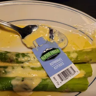 a plate of asparagus with cheese sauce