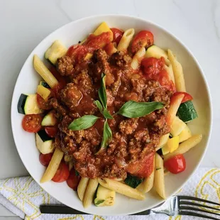 a plate of pasta with meat and vegetables