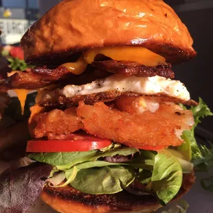 Local Bacon- Fresh Cracked Egg | Cheddar Cheese | Hash Brown | Spring Mix | Tomato | Aioli | Brioche Roll