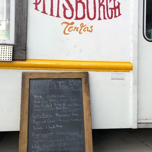 a menu written on the side of a food truck