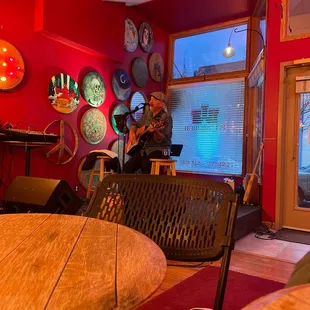 a man playing a guitar in a red room