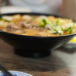 a bowl of soup and chopsticks