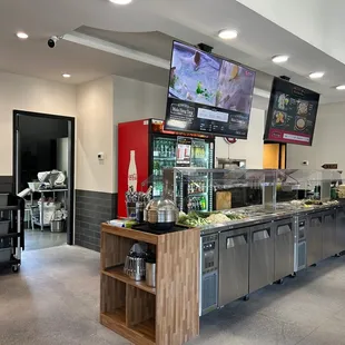 a kitchen area with a counter, televisions, and a bar