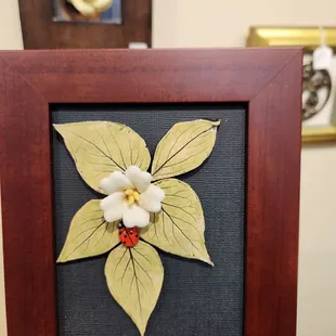A clay flower in a frame made by Ellen.
