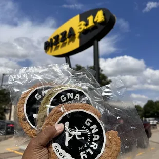  a hand holding two cookies