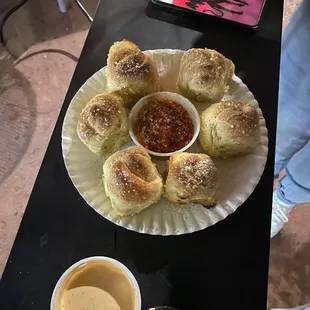  a plate of rolls and dipping sauce