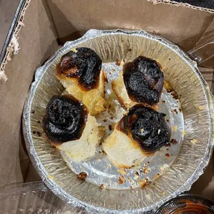 A failed attempt at garlic knots, sold upside down to hide the charred tops.