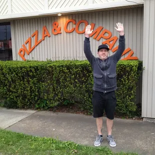 a man holding up a pizza sign