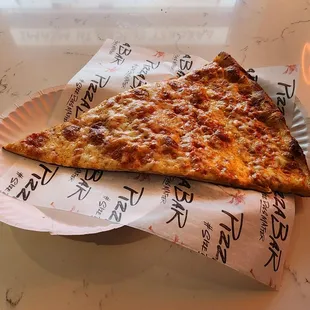 a slice of pizza on a paper plate