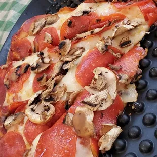 pepperoni, mushrooms, and cheese on a pizza pan