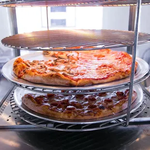 three pizzas on three tiered racks