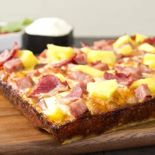 a pizza with pineapples and ham
