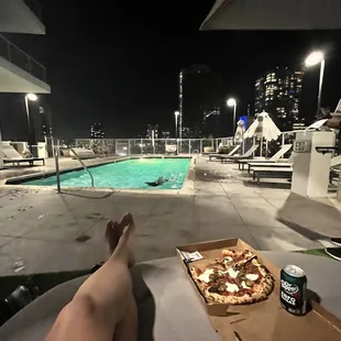 a person laying on a lounge chair next to a swimming pool