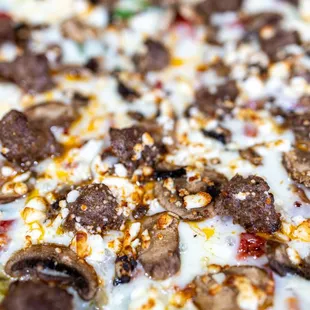 Via Tuscana (pesto sauce, whole-milk mozzarella cheese, mushrooms, spinach, sun-dried tomatoes, feta cheese and garlic) w/ added Sausage