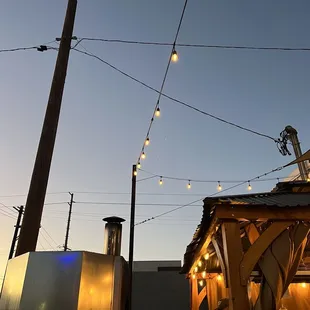 an outdoor restaurant with lights strung from the roof