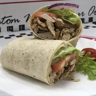 a burrito cut in half with lettuce and tomatoes