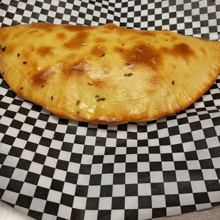 a piece of cheese pizza on a checkered paper