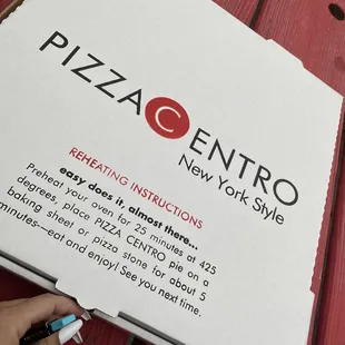 a hand holding a pizza box