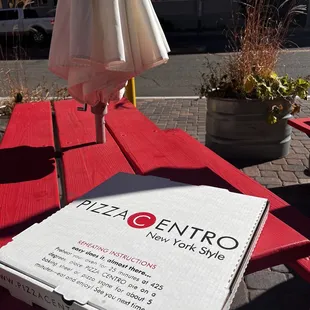 a pizza sitting on a red picnic table