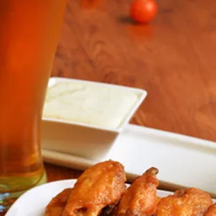 a plate of chicken wings and a glass of beer
