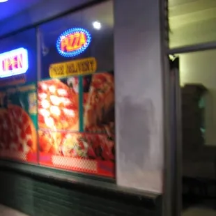 a pizza shop with neon signs