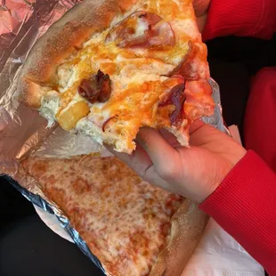 a person holding a slice of pizza