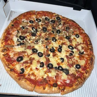 large pizza with black olives bacon, half mushroom half pineapple