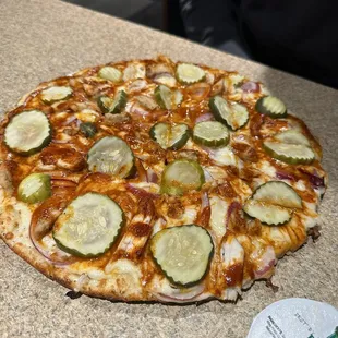 a pizza with pickles on it