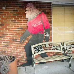 a statue of a woman sitting on a bench